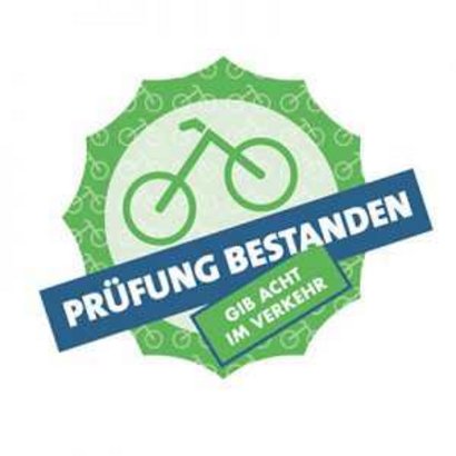 Runder Aufkleber mit der Aufschrift 'Prüfung bestanden' und einem Fahrrad.