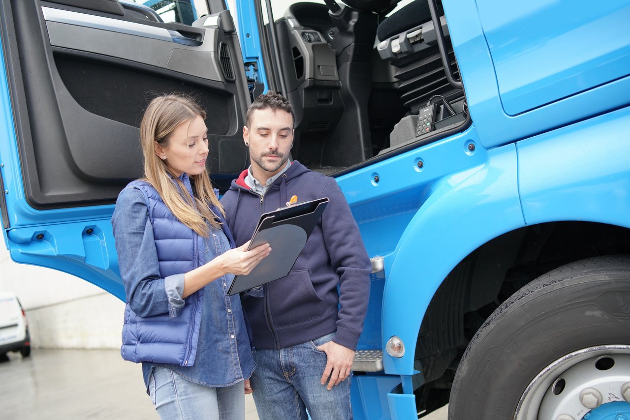 Frau und Mann stehen vor einer Lkw-Tür